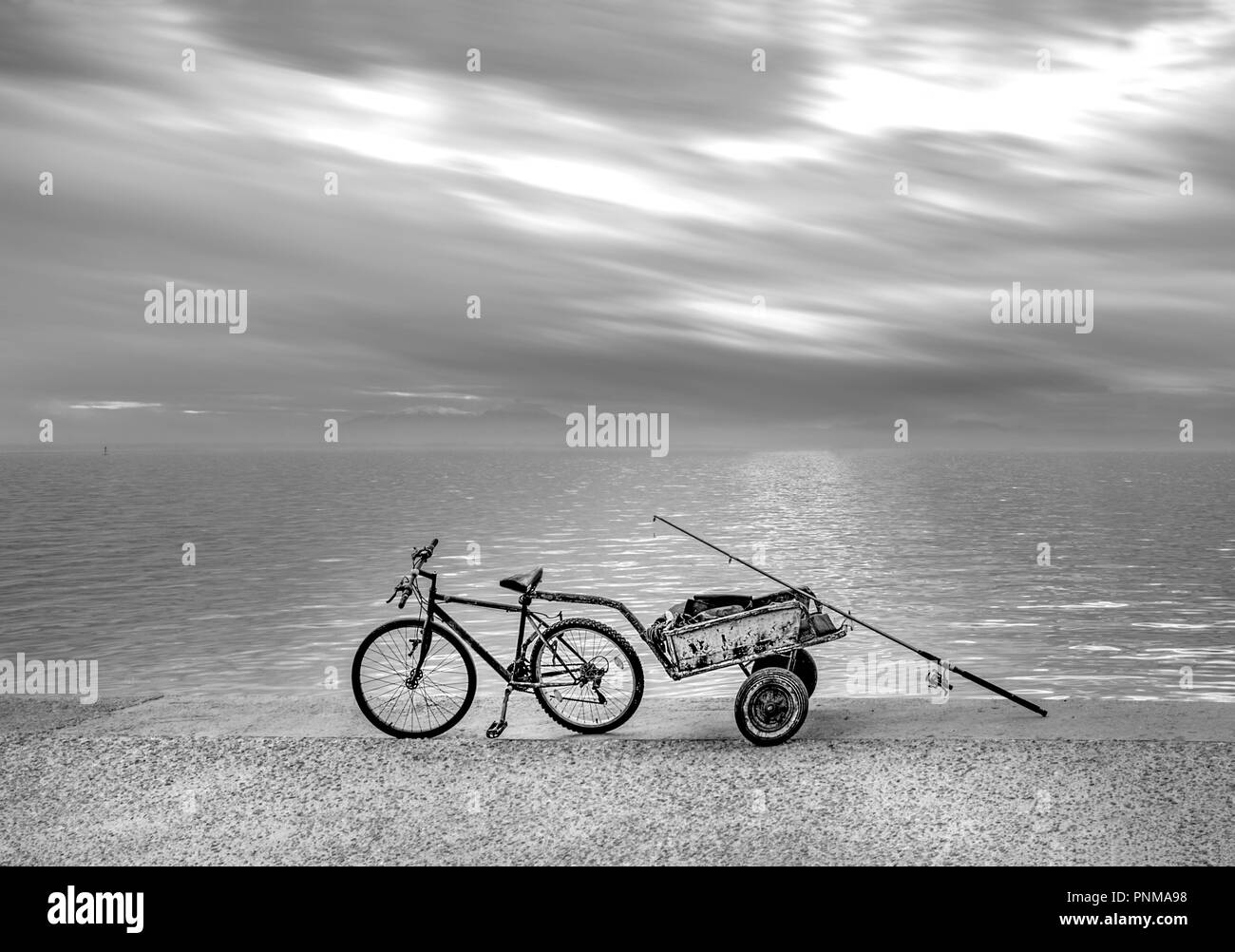 Fisherman's bicycle with trailer on seafront under a dramatic sky. Thessaloniki, Greece Stock Photo