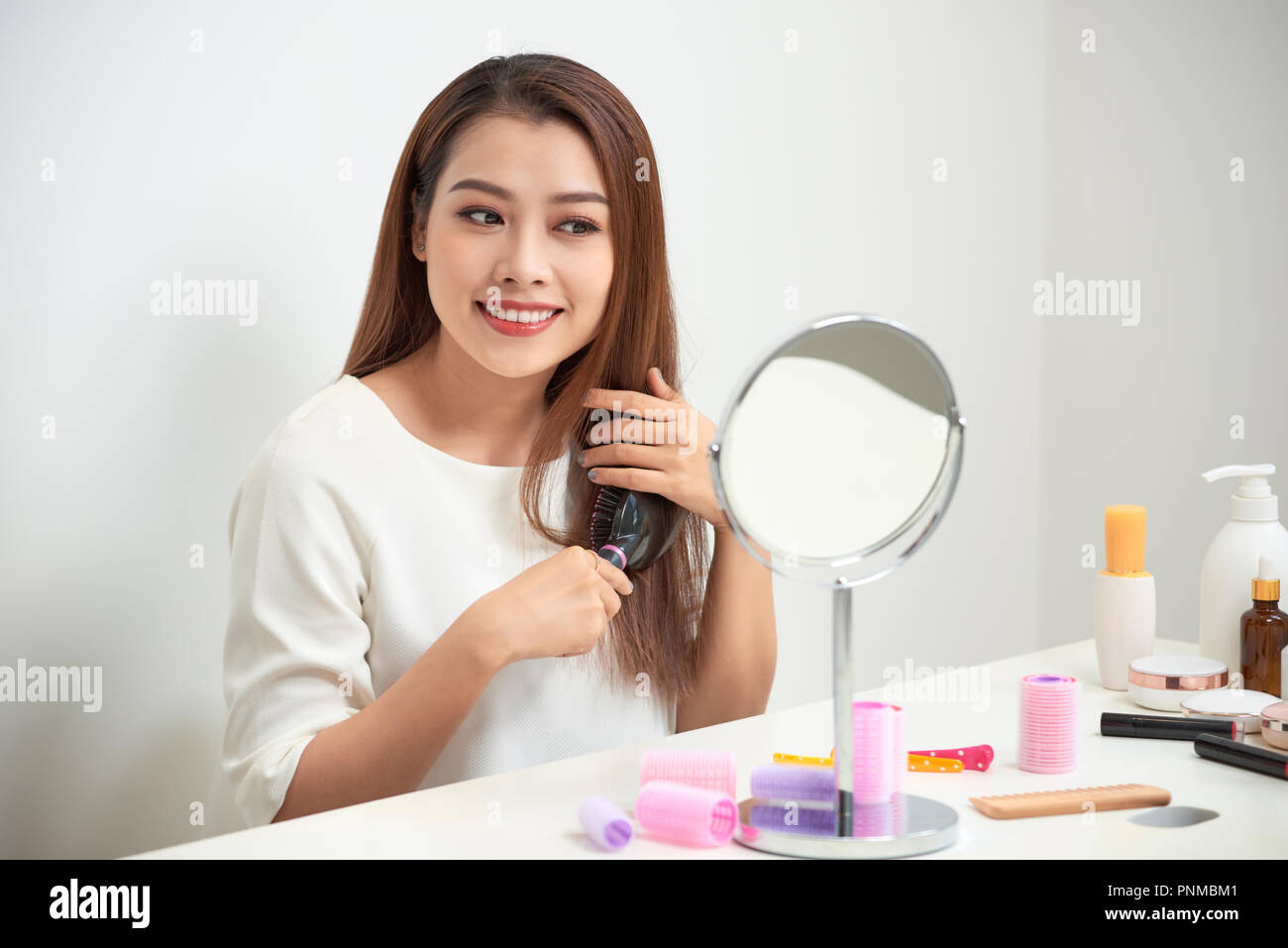 Mirror Tangles Getting rid of tangles. Beautiful young woman looking at her reflection ...