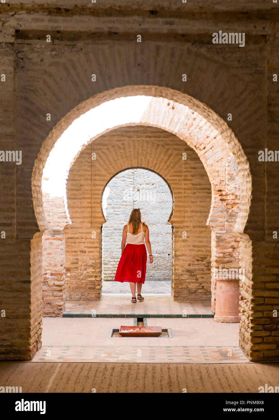 Woman with red dress, Arab baths, Alcázar de Jerez, Jerez de la Frontera, Cádiz province, Andalusia, Spain Stock Photo