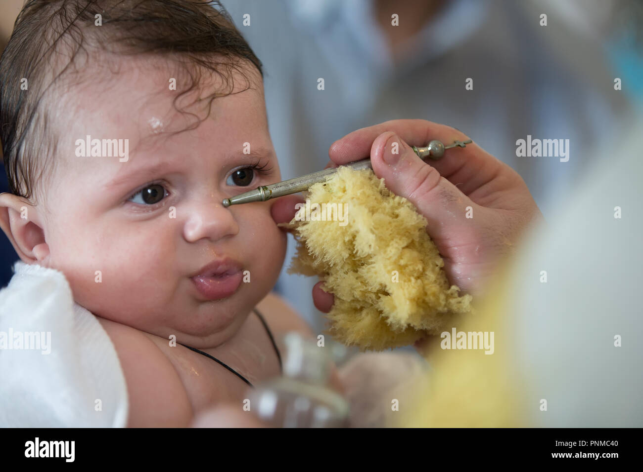 Baby at the rite of baptism. Accepting faith. Religious process of