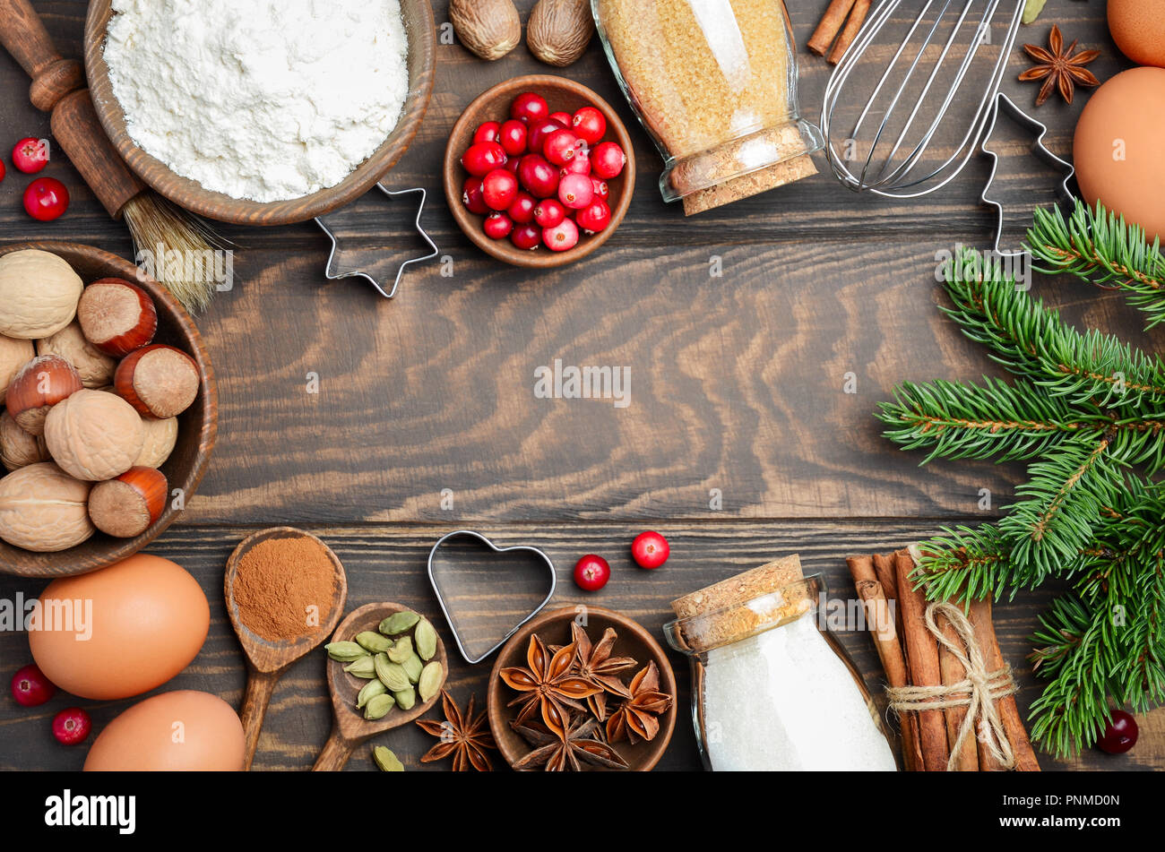 Christmas baking cake background. Ingredients and tools for baking - flour,  eggs, silicone molds in the shape of a Christmas tree, and a rolling pin on  a wooden background. Stock Photo
