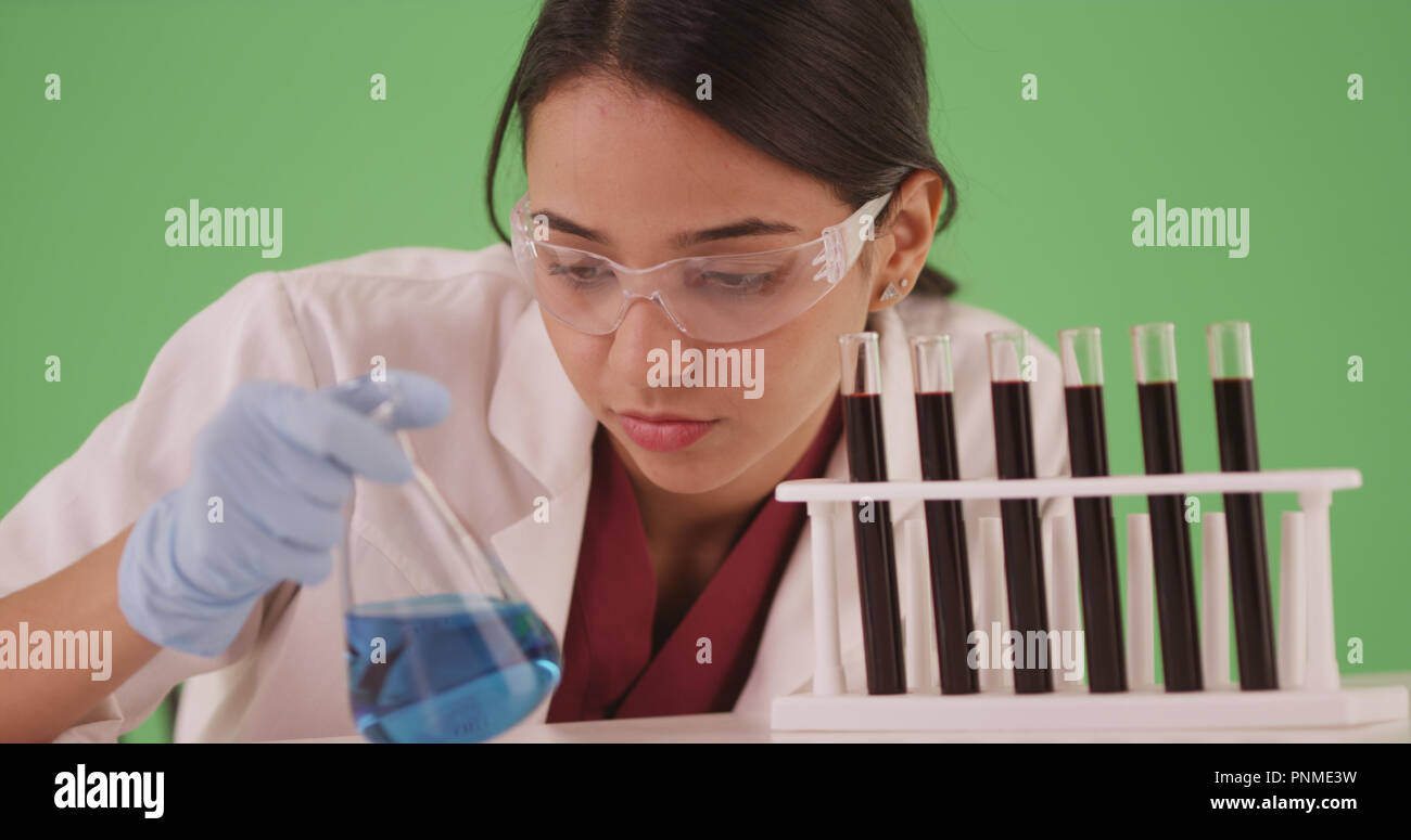 Young woman scientist or medical researcher with blood samples on greenscreen Stock Photo