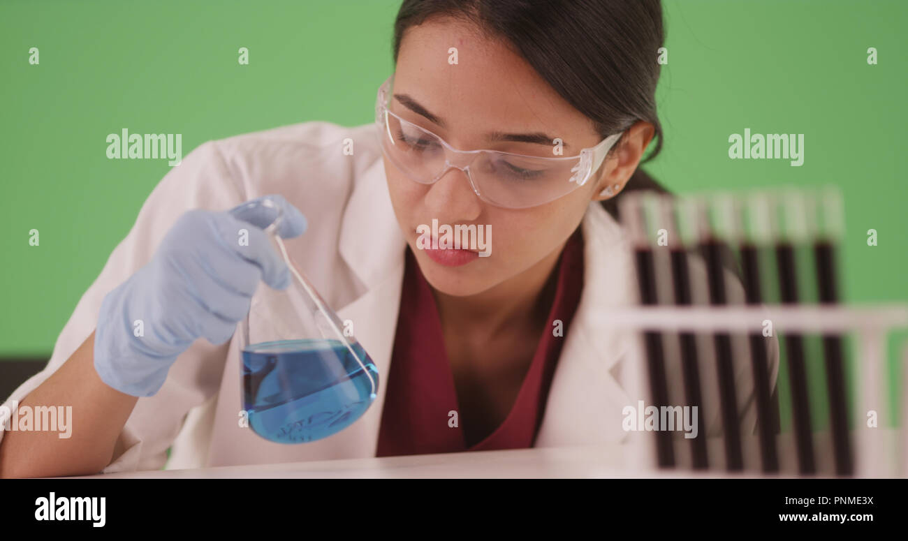Latina scientist or medical researcher with blood samples on greenscreen Stock Photo