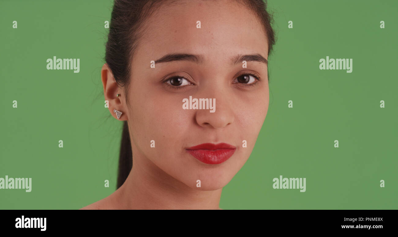 Closeup headshot of a latina girl with red lipstick on green screen