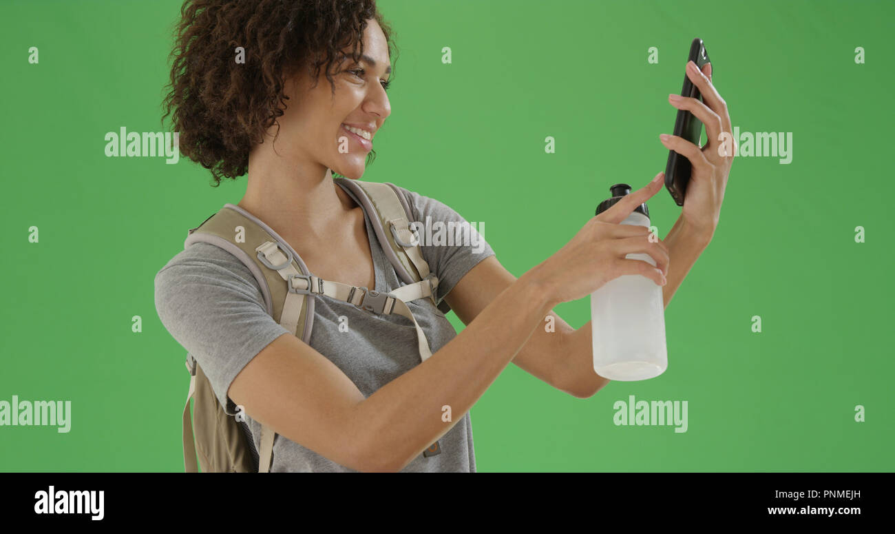 African American millennial girl takes a picture with her phone on green  screen Stock Photo - Alamy