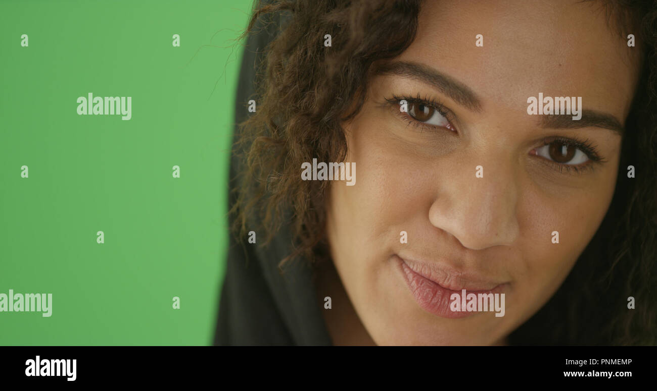 Close-up of a millennial black woman wearing hoodie on green screen Stock Photo