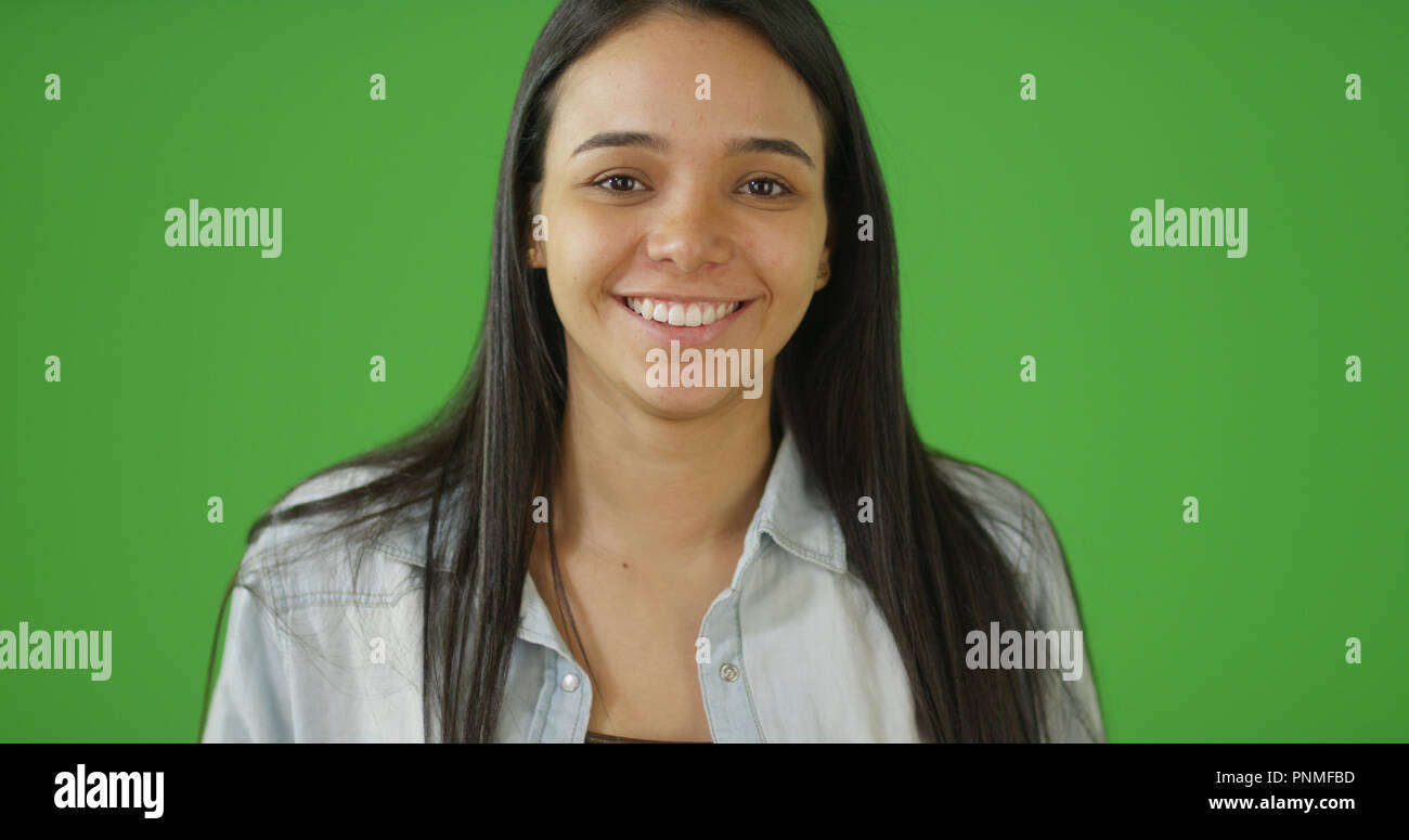 A smiling young girl looking at camera on green screen Stock Photo - Alamy