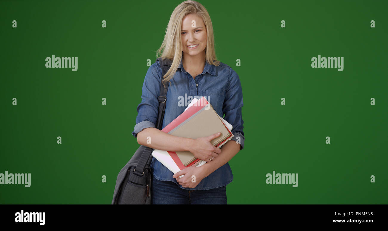 Lovely young female student standing on green screen Stock Photo - Alamy