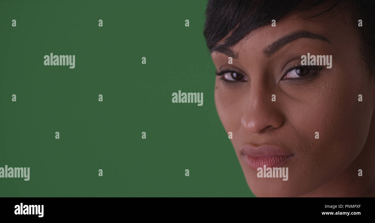 Close up of beautiful black woman looking at camera on green screen ...