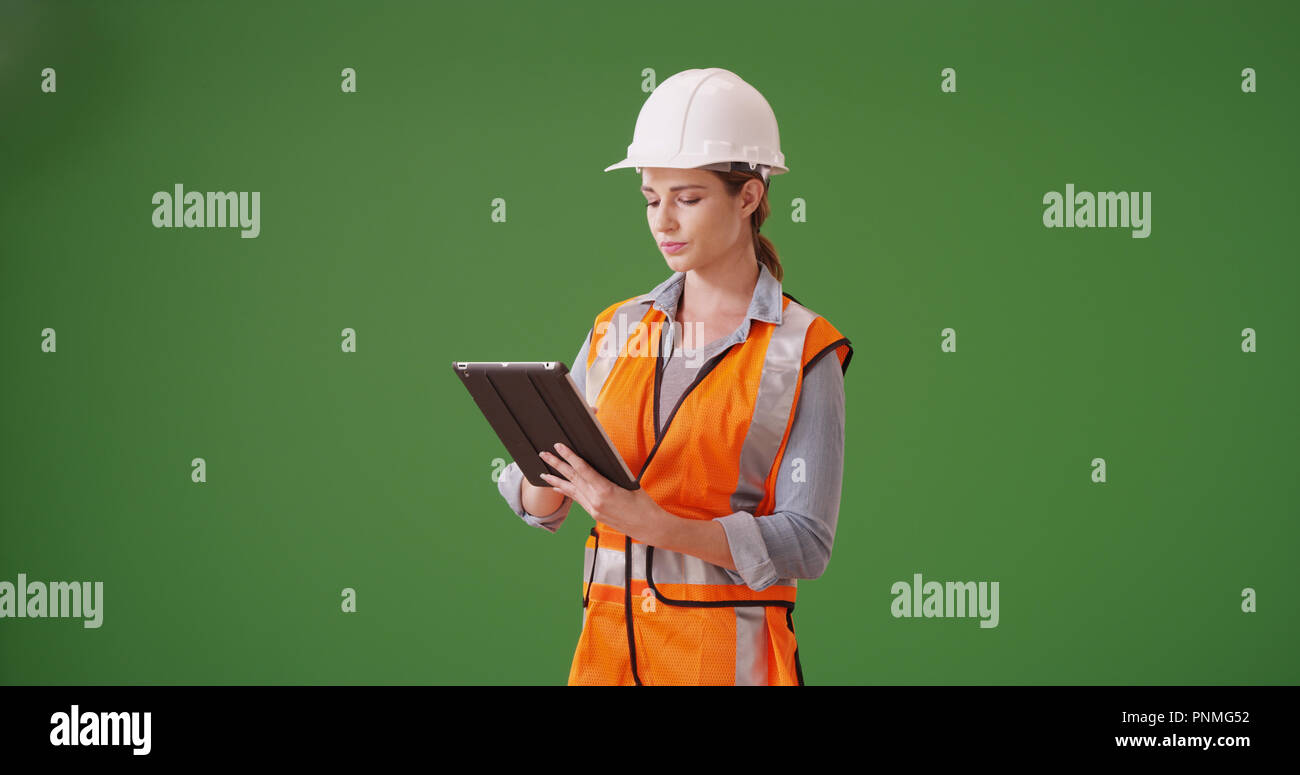 Young woman construction manager using tablet device on green screen Stock Photo