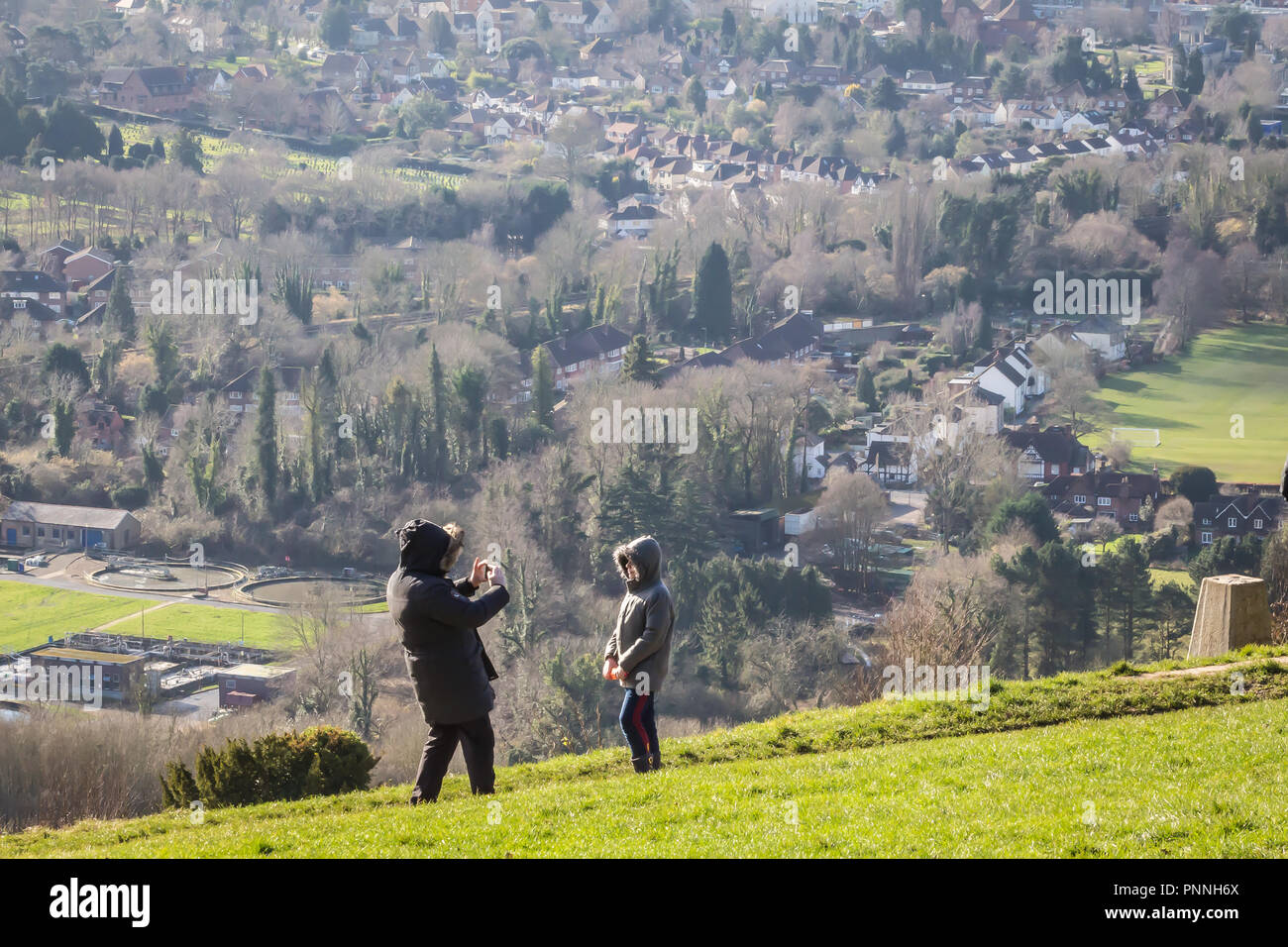 Box Hill near Reigate, Surrey, UK - April 2, 2018 - ? man takes a picture of his son with his smartphone camera; british countryside in the background Stock Photo