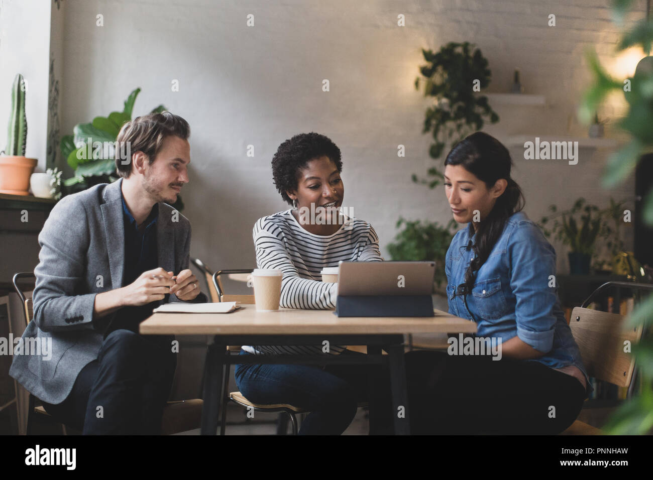 Coworkers having a meeting in a cafe Stock Photo