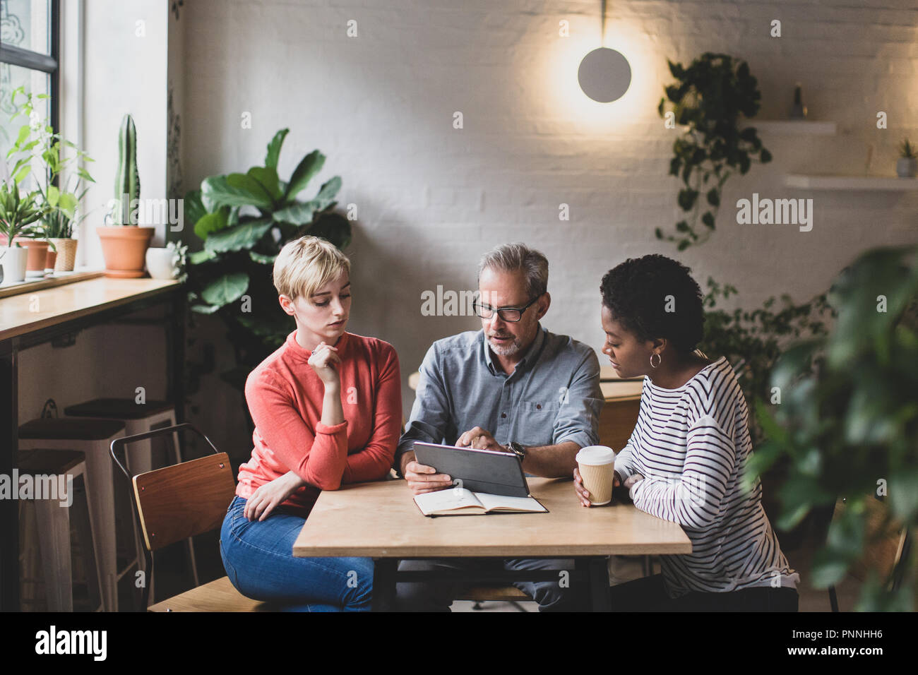 Coworkers having a meeting in a cafe Stock Photo