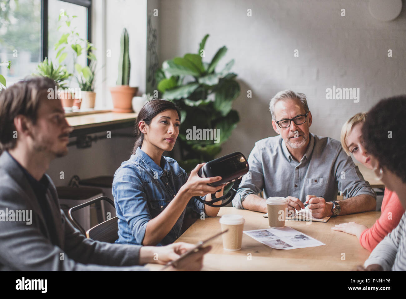 Coworkers discussing VR headset technology Stock Photo