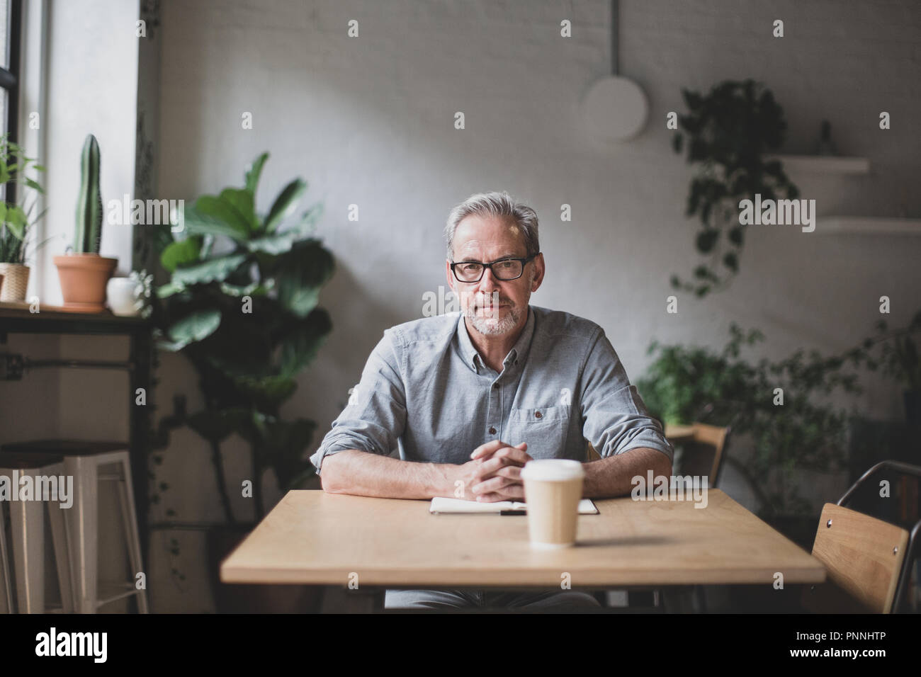Portrait of mature businessman working in a cafe Stock Photo