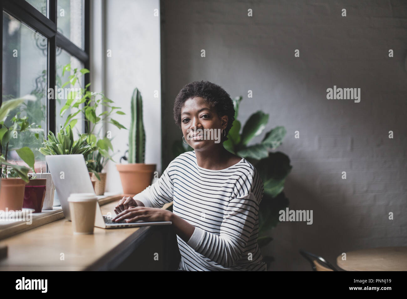 Portrait of a freelance african american businesswoman working in a cafe Stock Photo