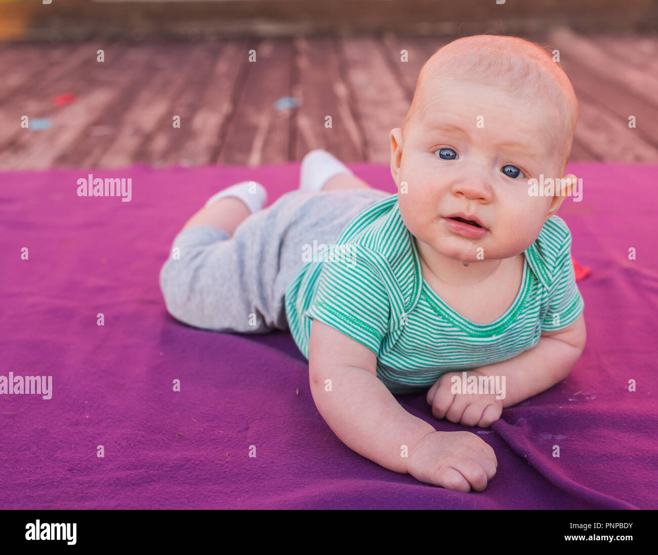 Cute child baby boy lying on blanket in summer day on nature. Family