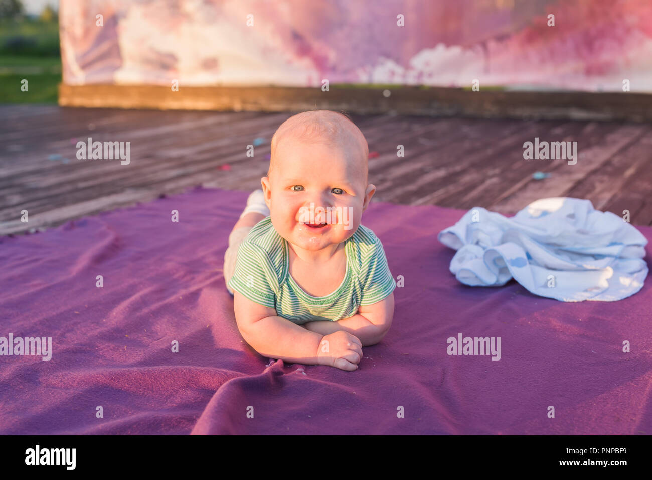 Cute child baby boy lying on blanket in summer day on nature. Family