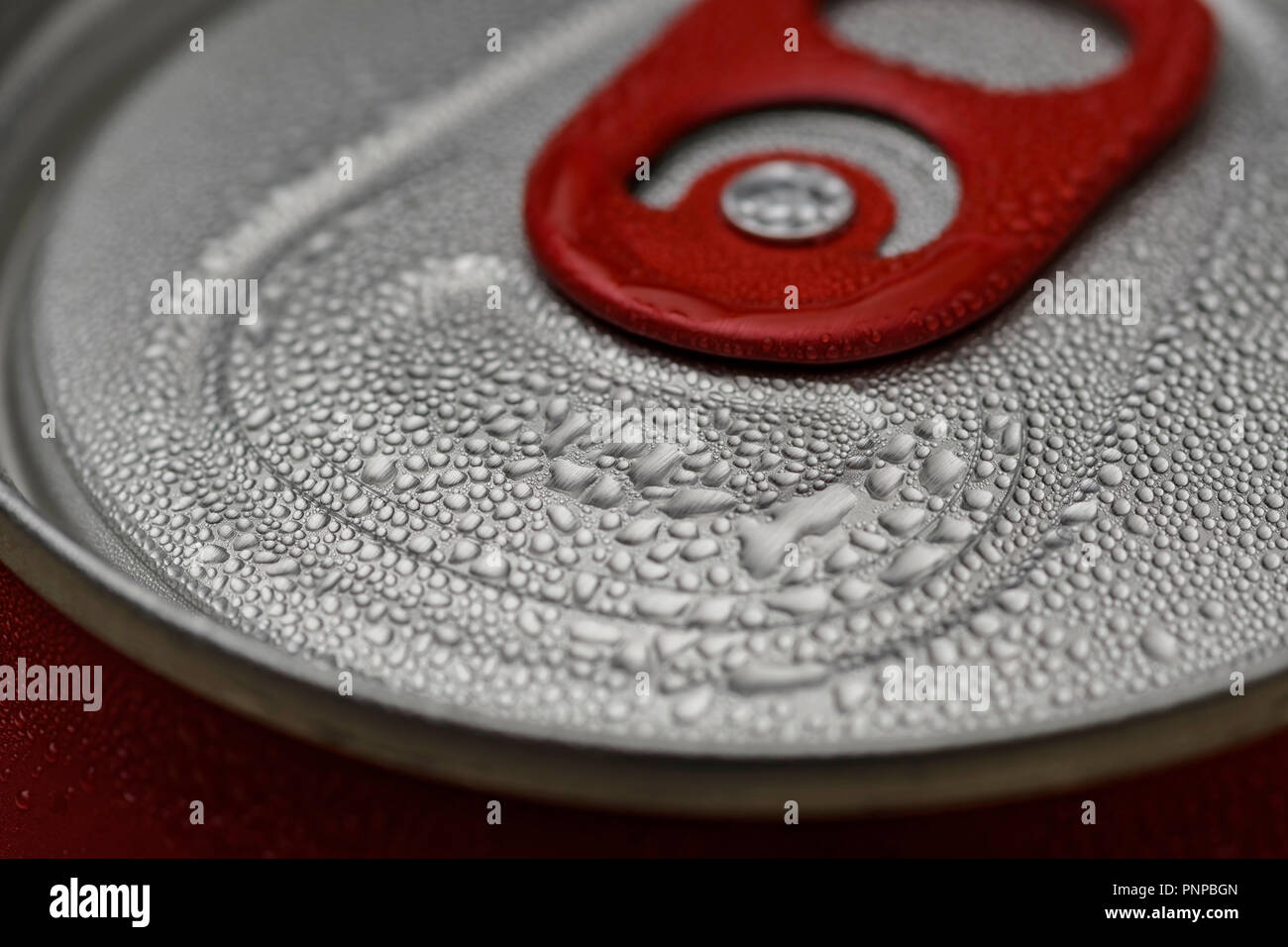 Red can opening tab close-up with condensation droplets Stock Photo