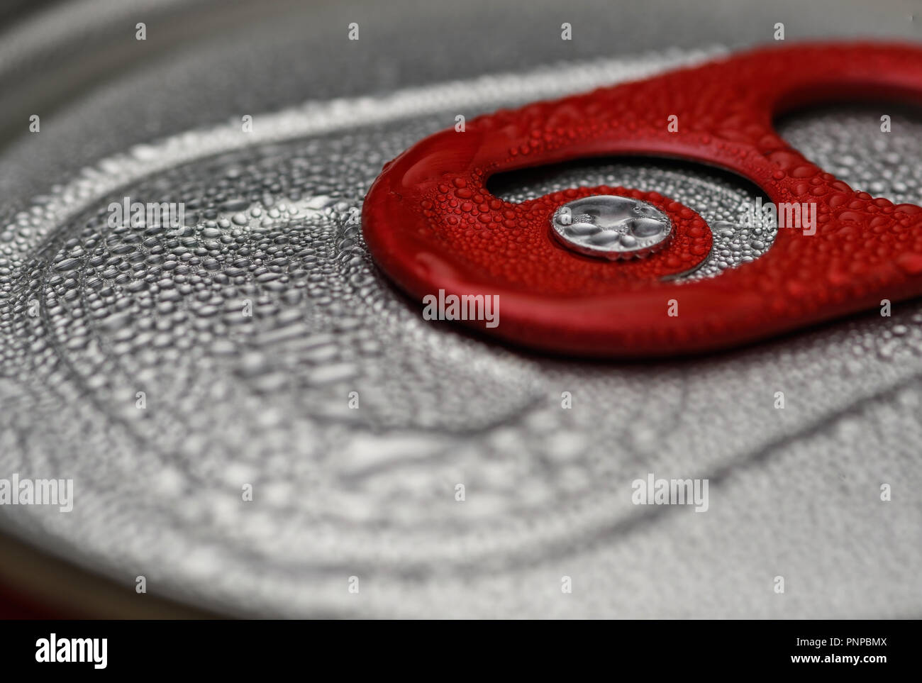Red can opening tab close-up with condensation droplets Stock Photo