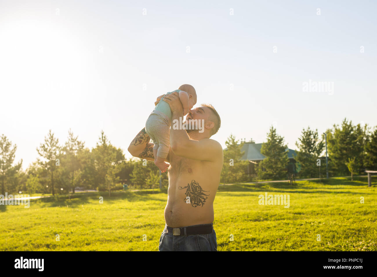 Happy father holding baby son, throwing baby in air. Concept of happy