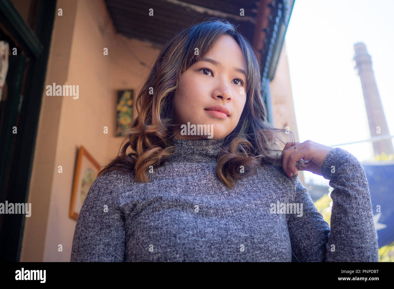 Young woman cheerfully sitting outside on a nice day Stock Photo