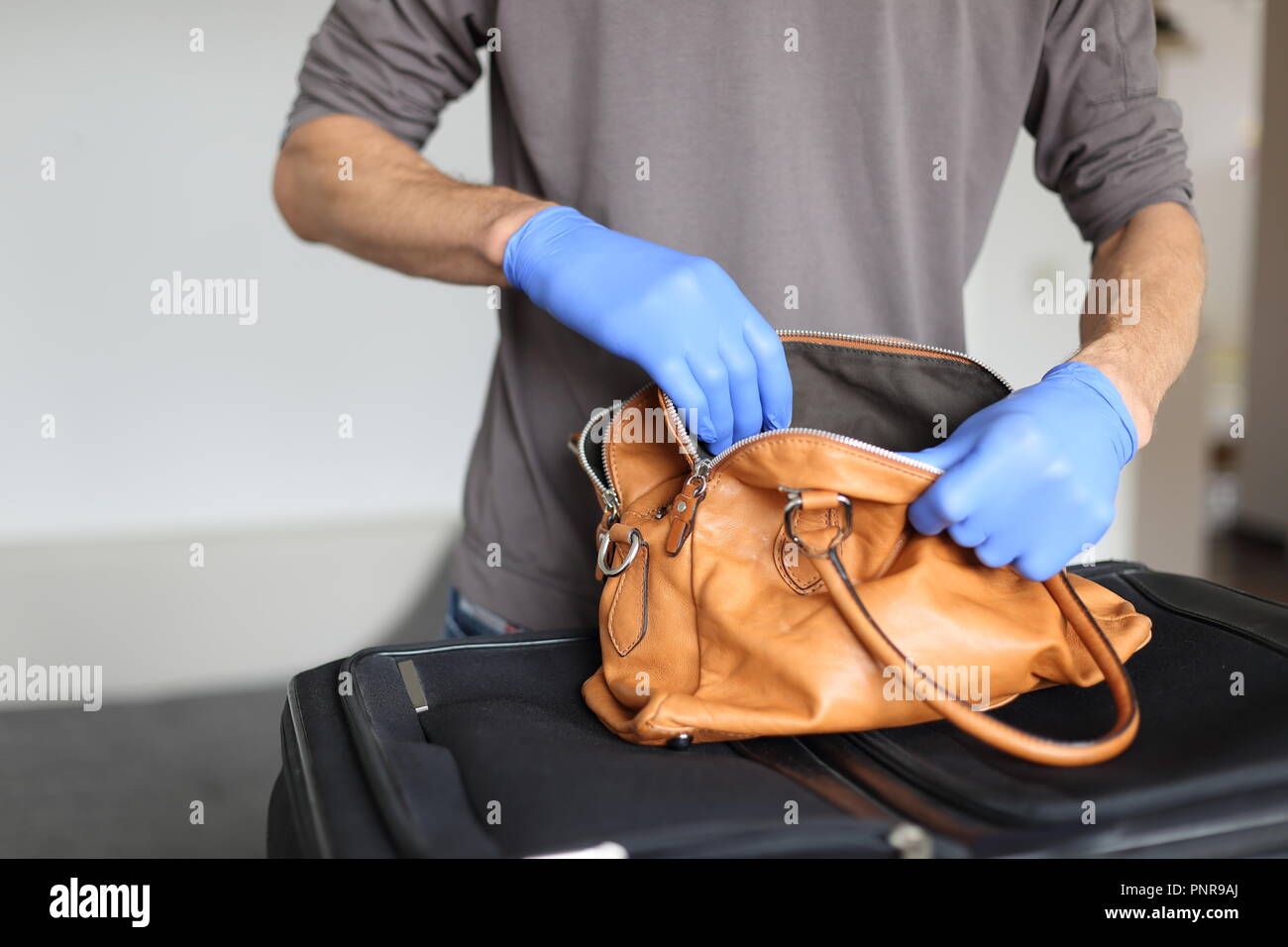 A Customs at airport doing security check of hand baggage Stock Photo