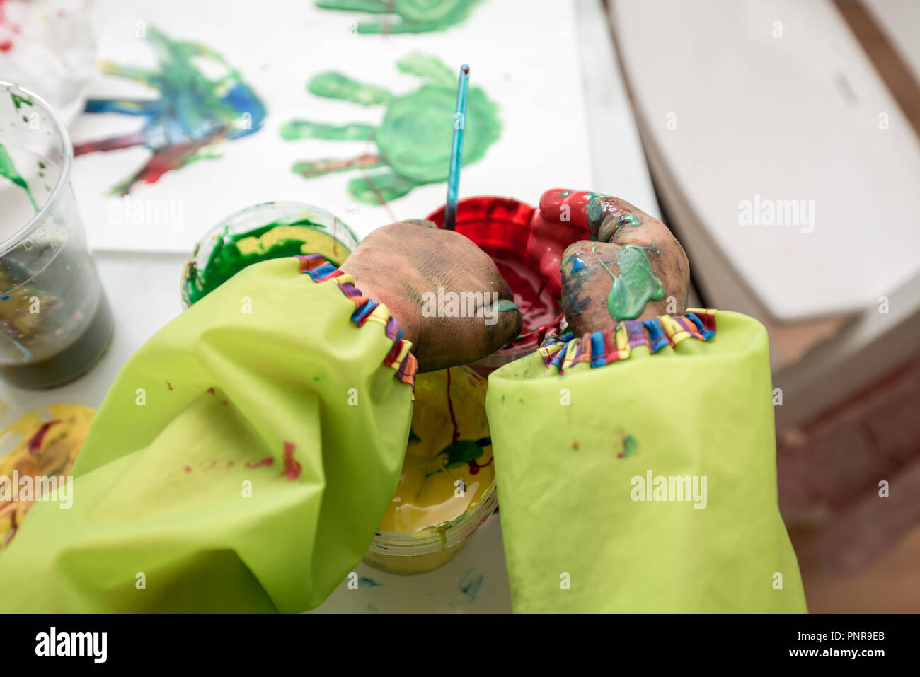 closeup view of little hands scooping and mixing colourful finger