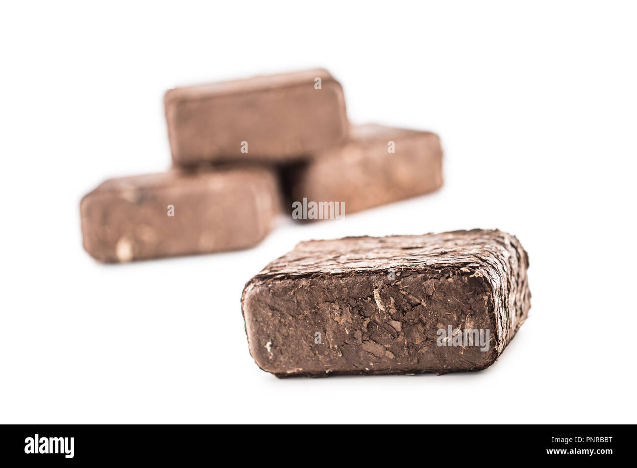 Wooden pressed briquettes from biomass on a white isolated background. Stock Photo