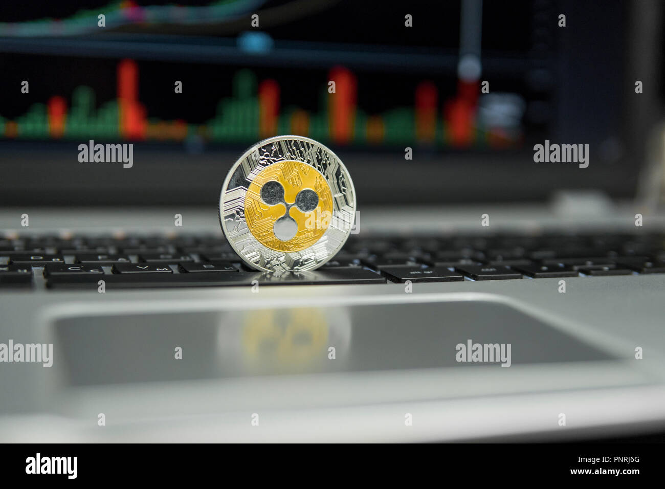 Silver Ripple Screen Golden and Silver Ripple coin on a black keyboard of silver laptop and ...