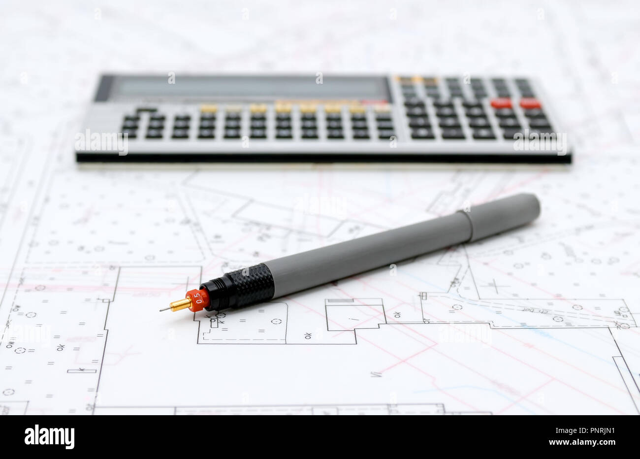 Architectural plans, calculator and drawing utensils Stock Photo