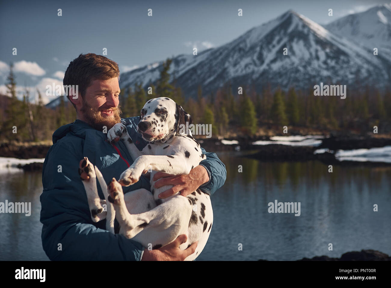Man playing with his dog outdoors mountain terrain Stock Photo