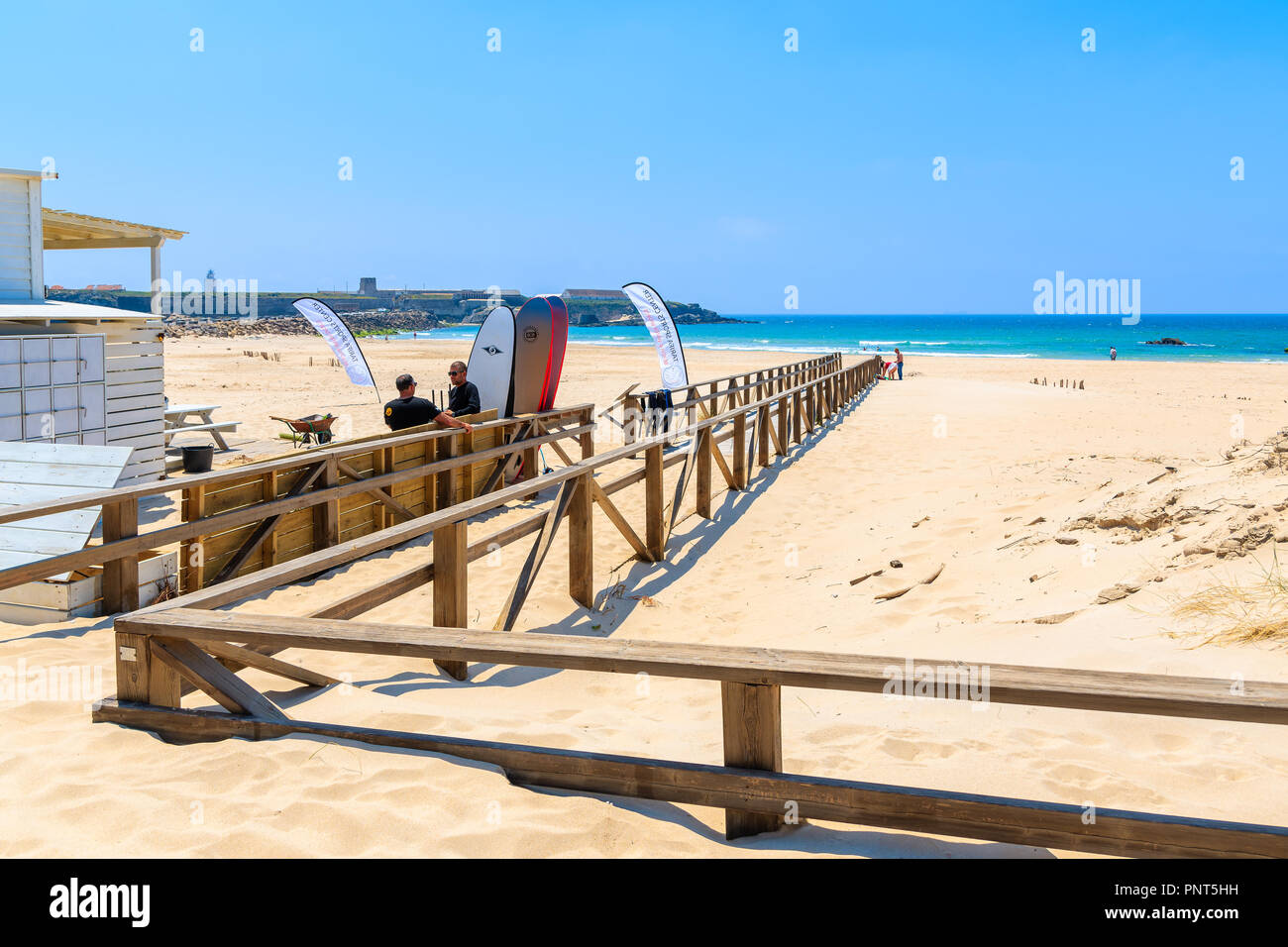 TARIFA BEACH, SPAIN - MAY 8, 2018: Surfers standing at entrance to beach on sunny beautiful day. Andalusia is hottest province of the country and attr Stock Photo