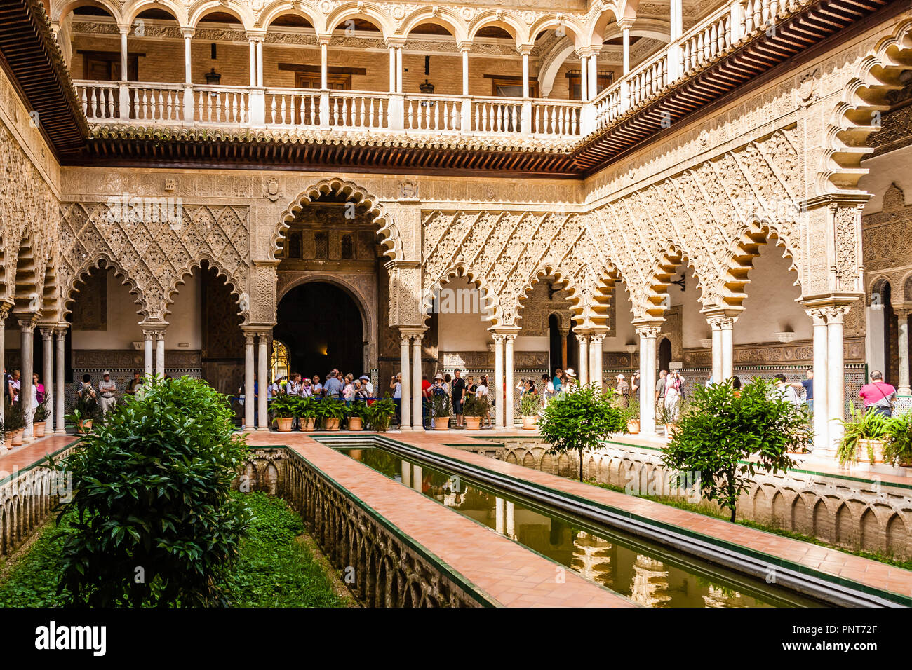 Tourists in the inner courtyard of the Reales Alcazares, Seville, Spain. Stock Photo