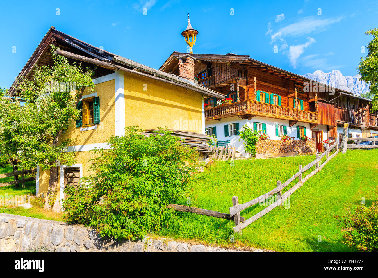 Typical wooden alpine houses on green meadow in Going am Wilden Kaiser ...