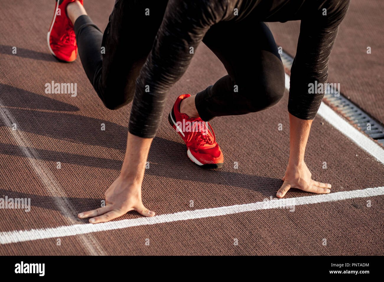 athlete on starting position at running track. Runner practicing run in