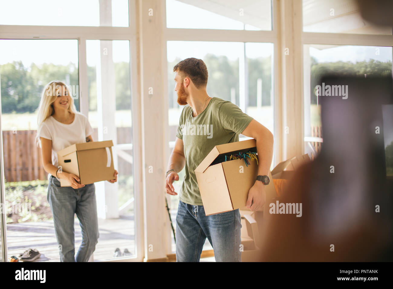 Happy Couple Carrying Cardboard Boxes Into New Home On Moving Day Stock ...