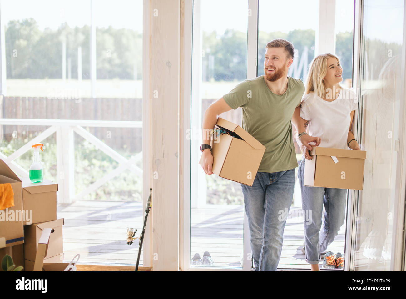 Happy Couple Carrying Cardboard Boxes Into New Home On Moving Day Stock ...