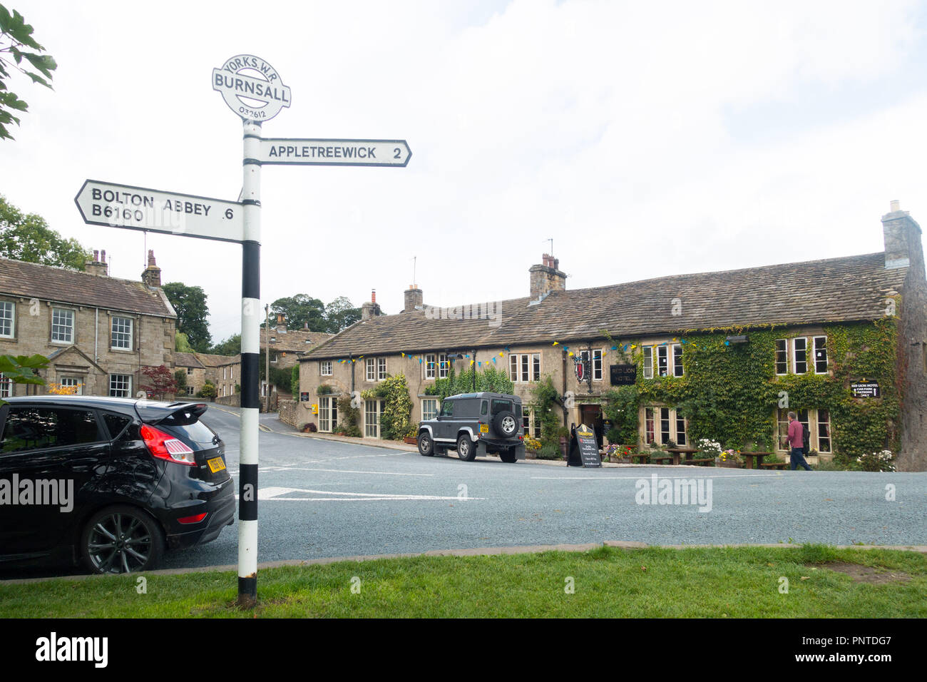 The village of Burnsall, a centre for walking in Upper Wharfedale, Yorkshire, UK, with the Red Lion Hotel in the background Stock Photo