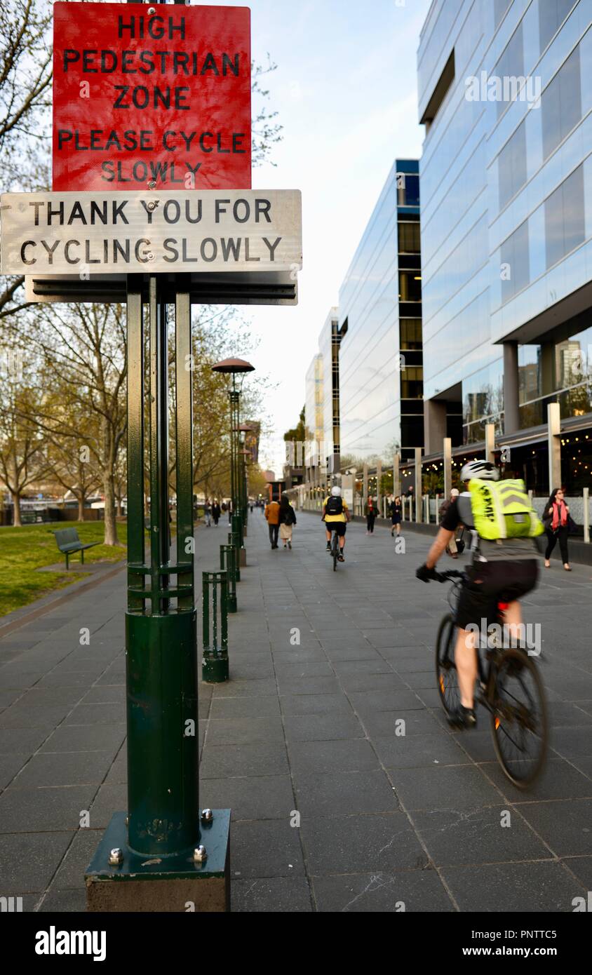 Cyclists riding past a thank you for cycling slowly sign, Melbourne VIC ...