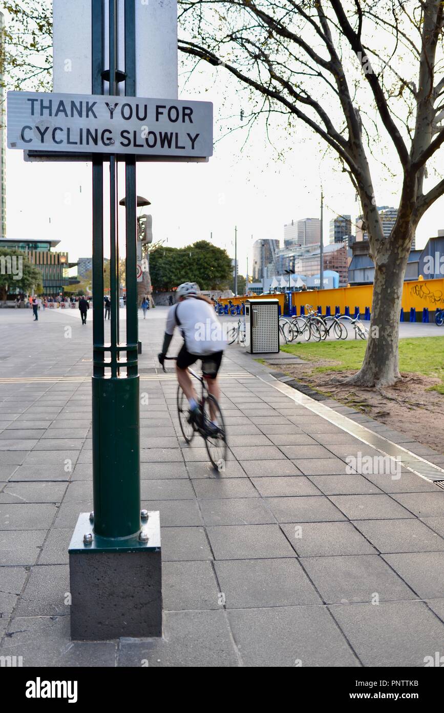 Cyclists riding past a thank you for cycling slowly sign, Melbourne VIC ...