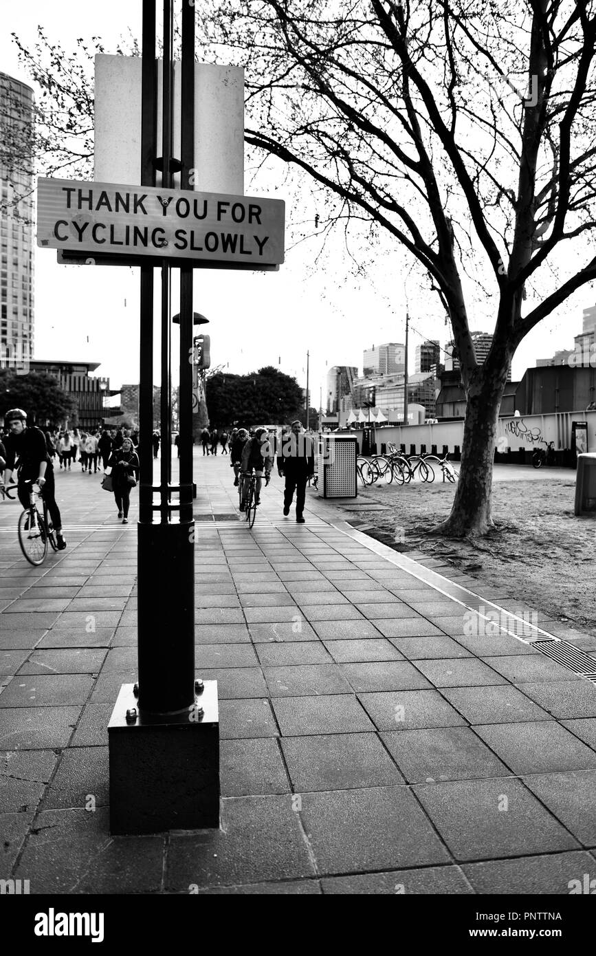 Cyclists riding past a thank you for cycling slowly sign, Melbourne VIC ...