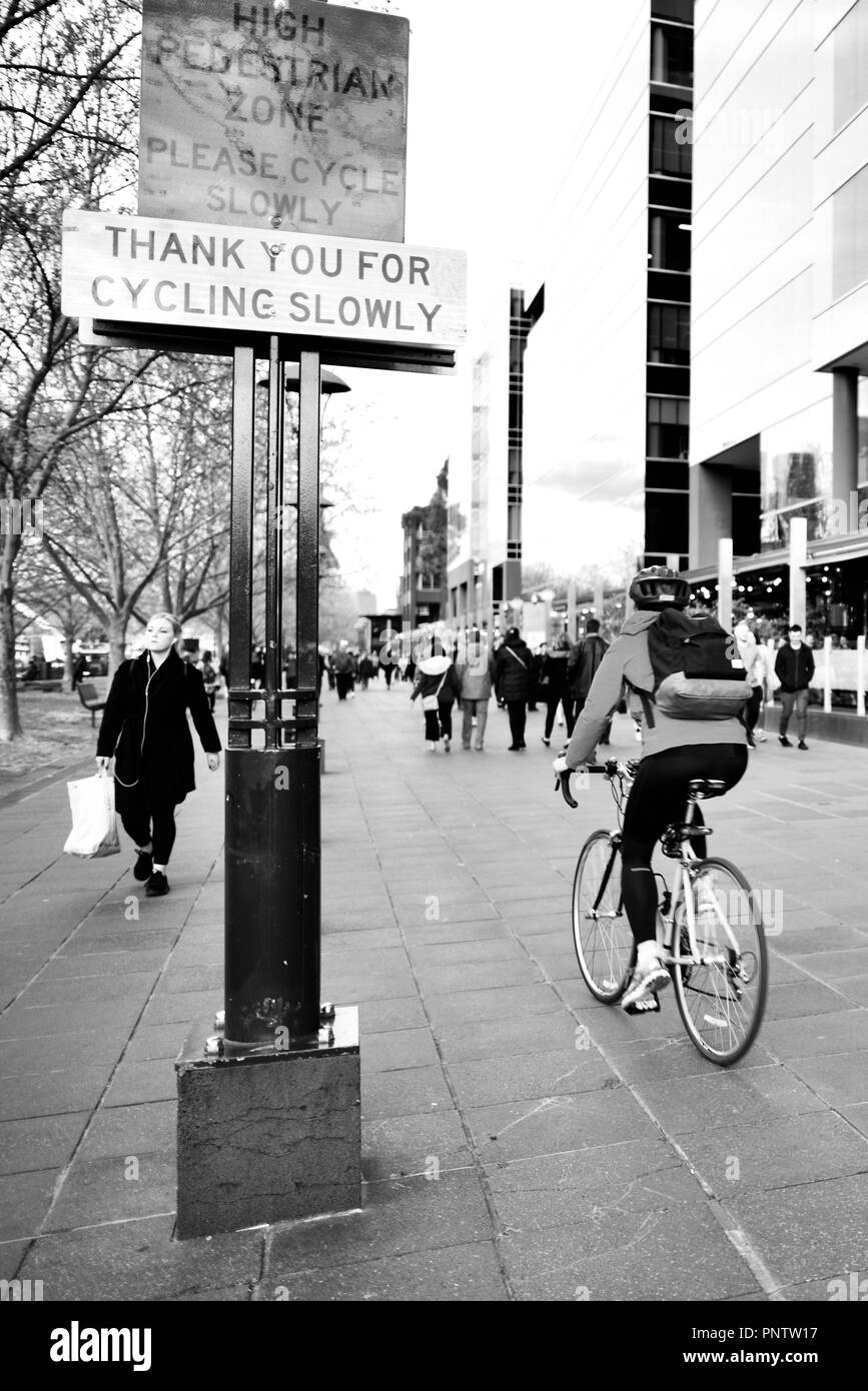 Cyclists riding past a thank you for cycling slowly sign, Melbourne VIC ...
