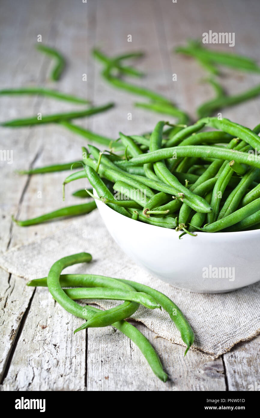green string beans in a bowl on rustic wooden table Stock Photo - Alamy