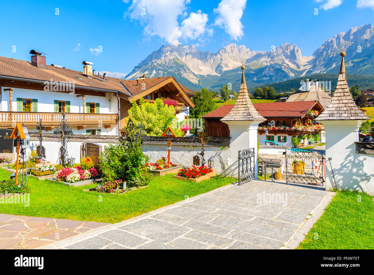 TYROL, AUSTRIA - JUL 29, 2018: Entrance to church and view of Going am Wilden Kaiser village on sunny summer day. This place is most beautiful village Stock Photo