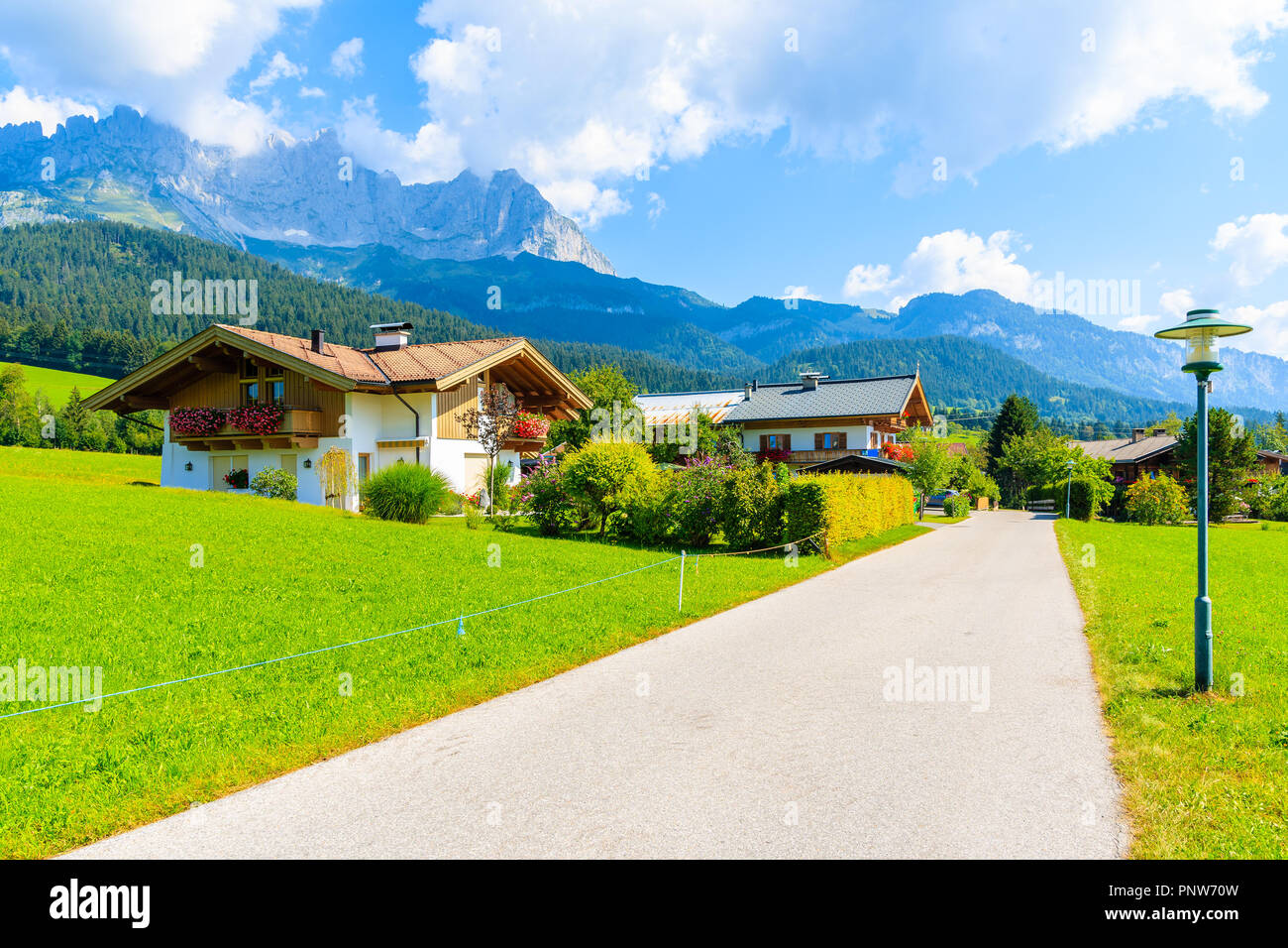 Road in Going am Wilden Kaiser mountain village on sunny summer day and beautiful traditional houses decorated with flowers, Tyrol, Austria Stock Photo