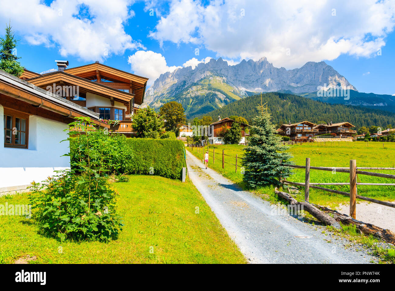 Road in Going am Wilden Kaiser mountain village on sunny summer day and beautiful traditional houses decorated with flowers, Tyrol, Austria Stock Photo