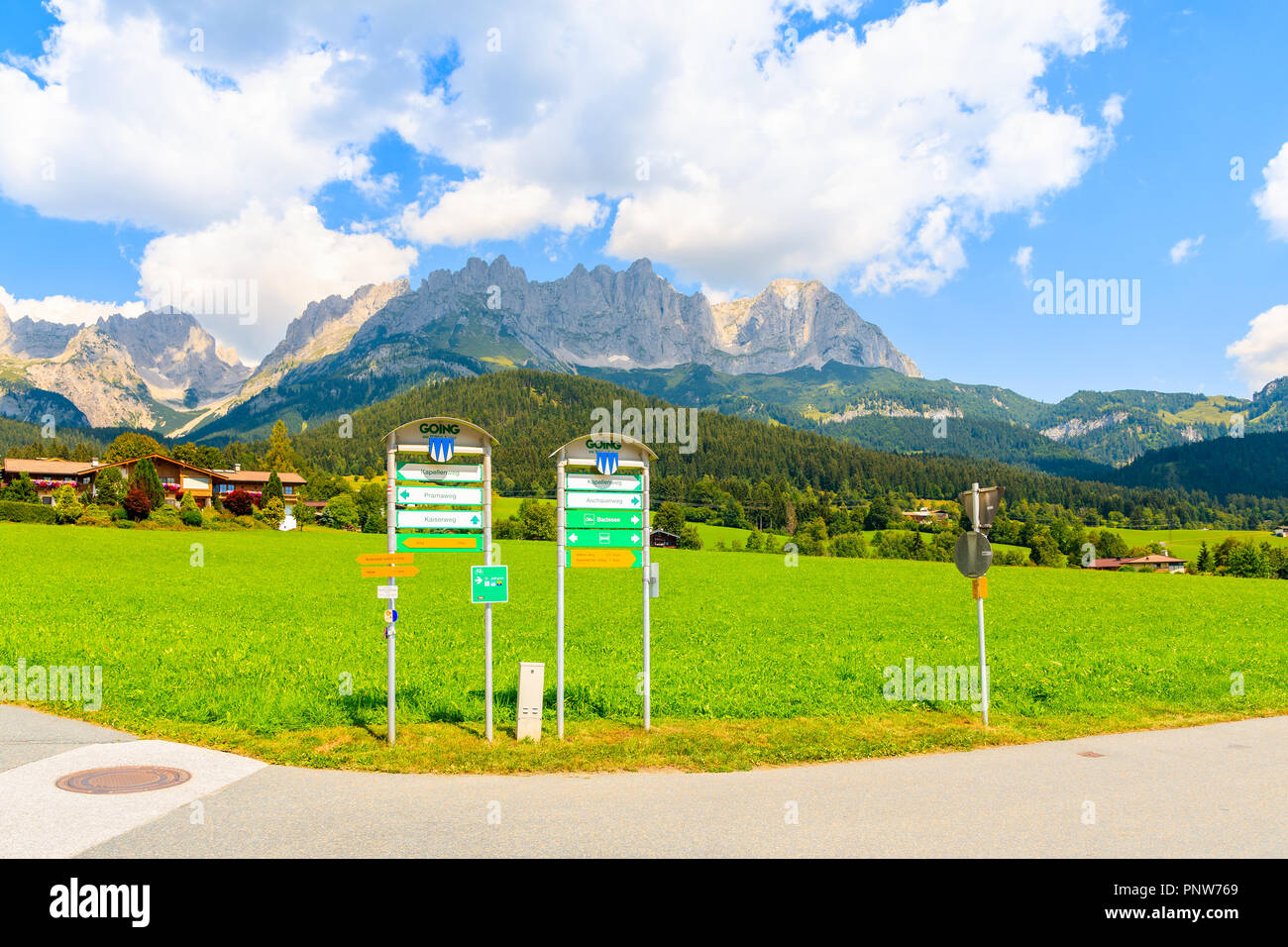 TYROL, AUSTRIA - JUL 29, 2018: Walking and cycling signs on road in Going am Wilden Kaiser mountain village on sunny summer day. This place is most be Stock Photo