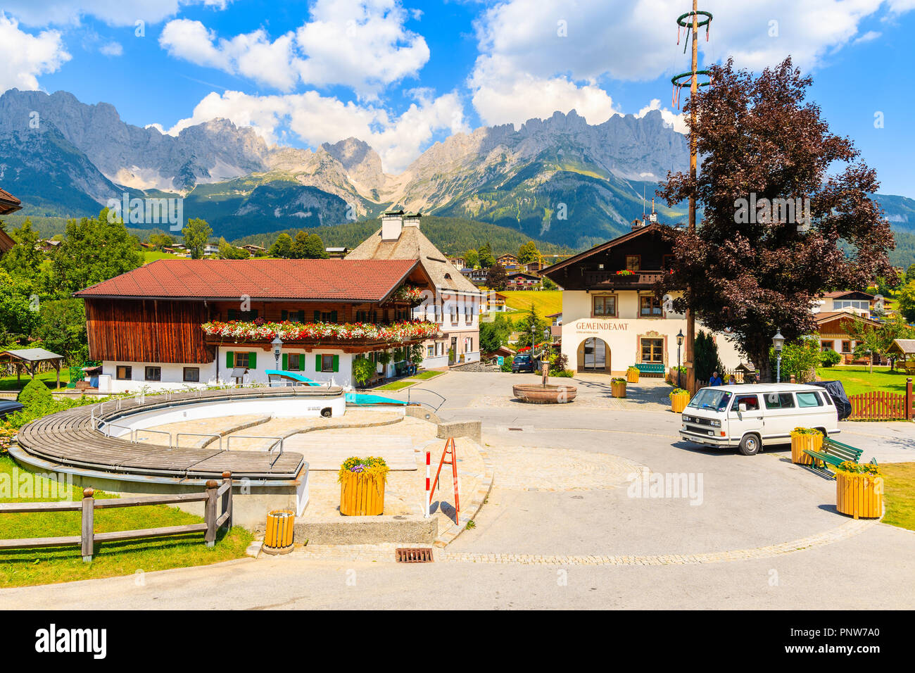 TYROL, AUSTRIA - JUL 30, 2018: Typical houses on church square in Going am Wilden Kaiser mountain village on sunny summer day. This place is most beau Stock Photo