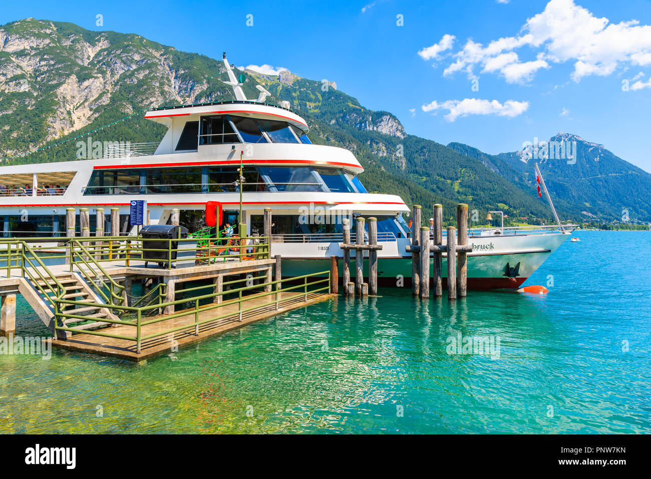 ACHENSEE LAKE, AUSTRIA - JUL 31, 2018: Tourist ship mooring at pier on shore of Achensee lake on sunny summer day, Tirol. During summer daily boat tri Stock Photo